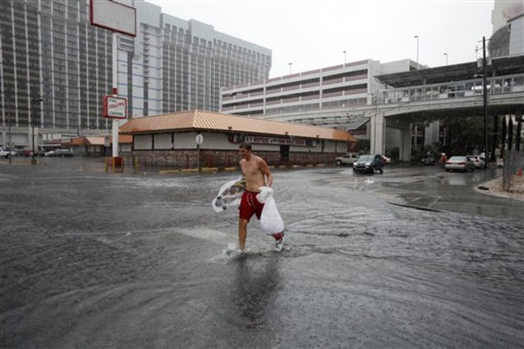Taylor Bradley walks across a flooded street behind the Flamingo hotel and casino in Las Vegas, Nev., on Tuesday.
